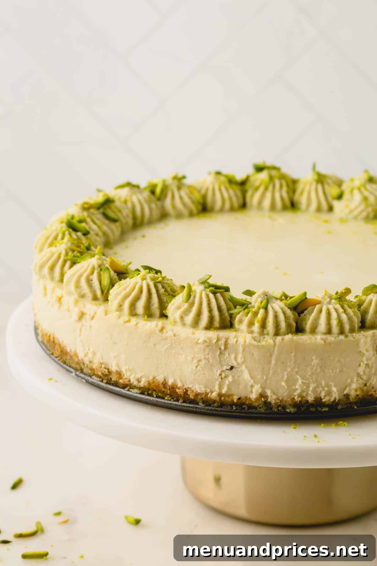 Pistachio cheesecake on a marble cake pedestal.