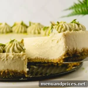 A slice of pistachio cheesecake being taken out with a cake server.
