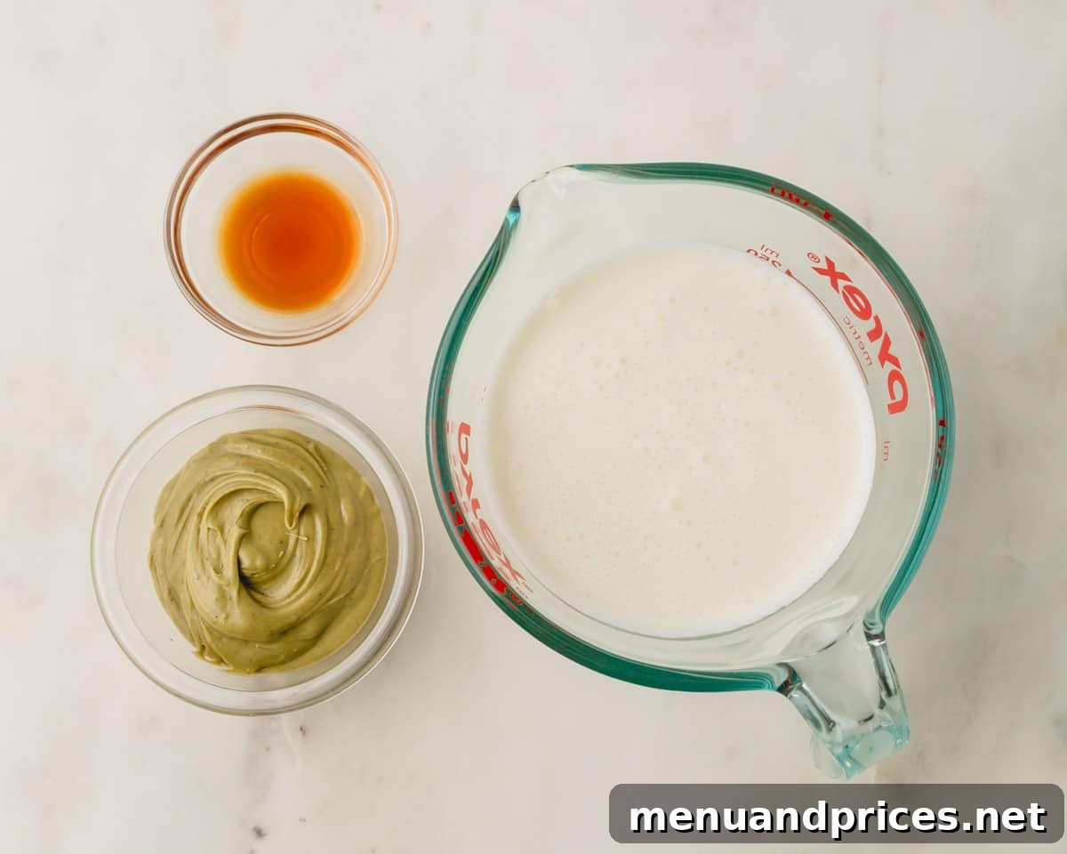 A bowl of pistachio butter, vanilla extract, and a measuring cup of heavy cream for pistachio whipped cream.