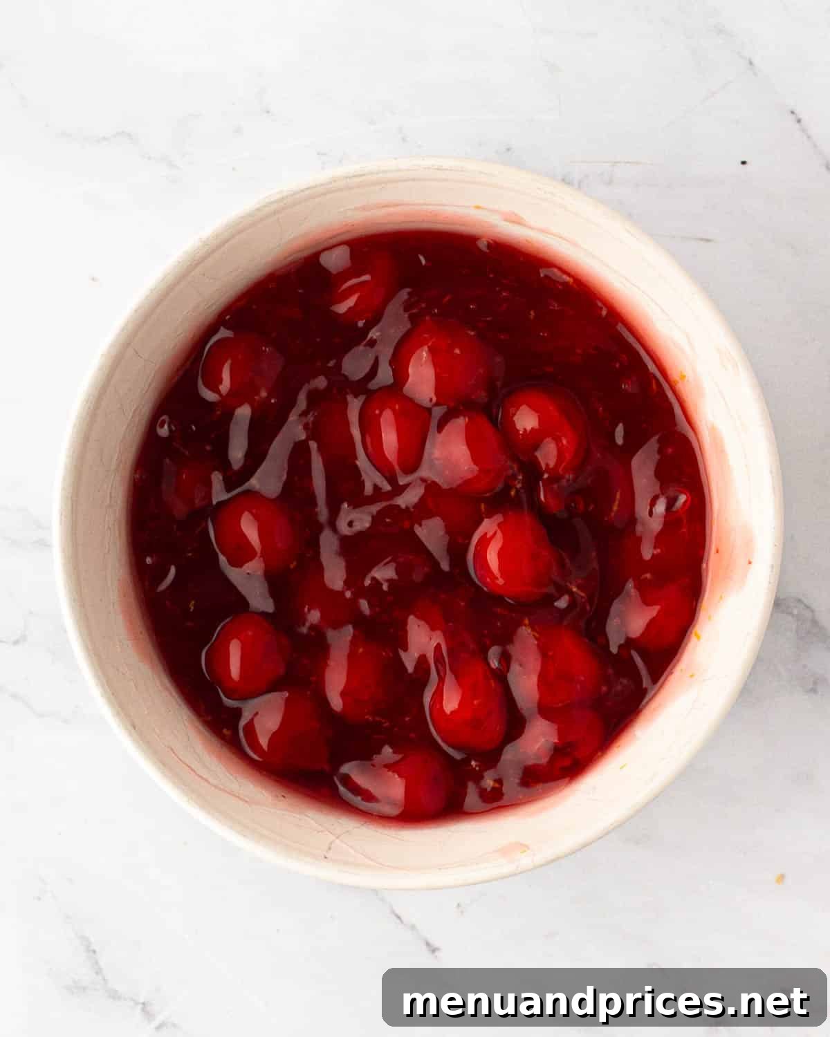 A white bowl with cherry pie filling.