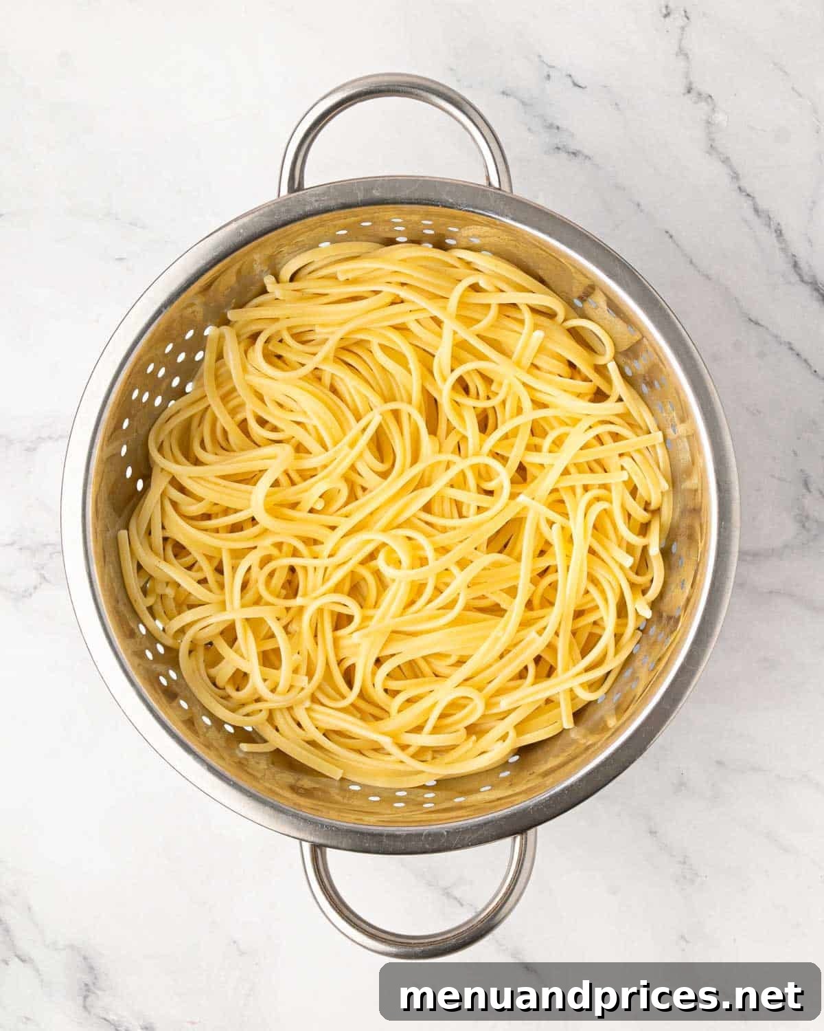 Lemon Artichoke Pasta with Garlic, Parmesan and Herbs 4 A colander with boiled noodles.